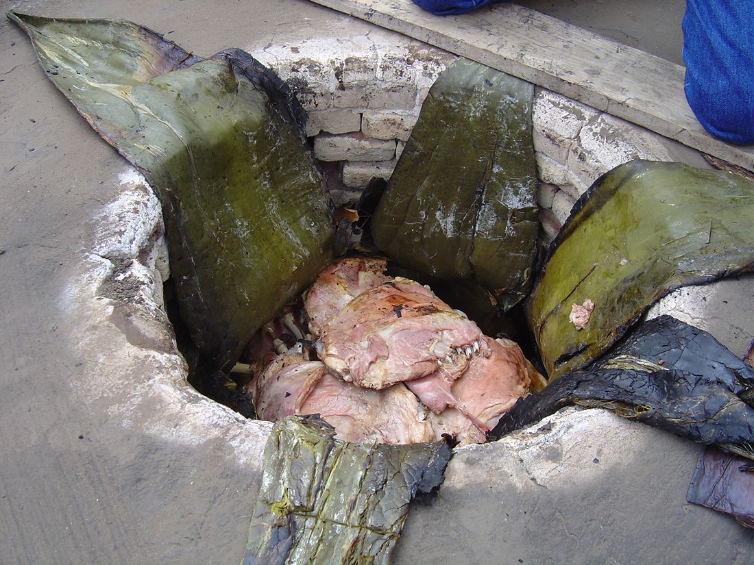 Barbacoa de borrego cocida en horno de tierra, envuelta en hojas